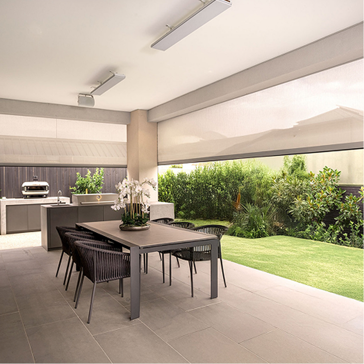 Modern covered patio with a dining table, six chairs, potted orchids, outdoor kitchen, and view of green lawn and garden.