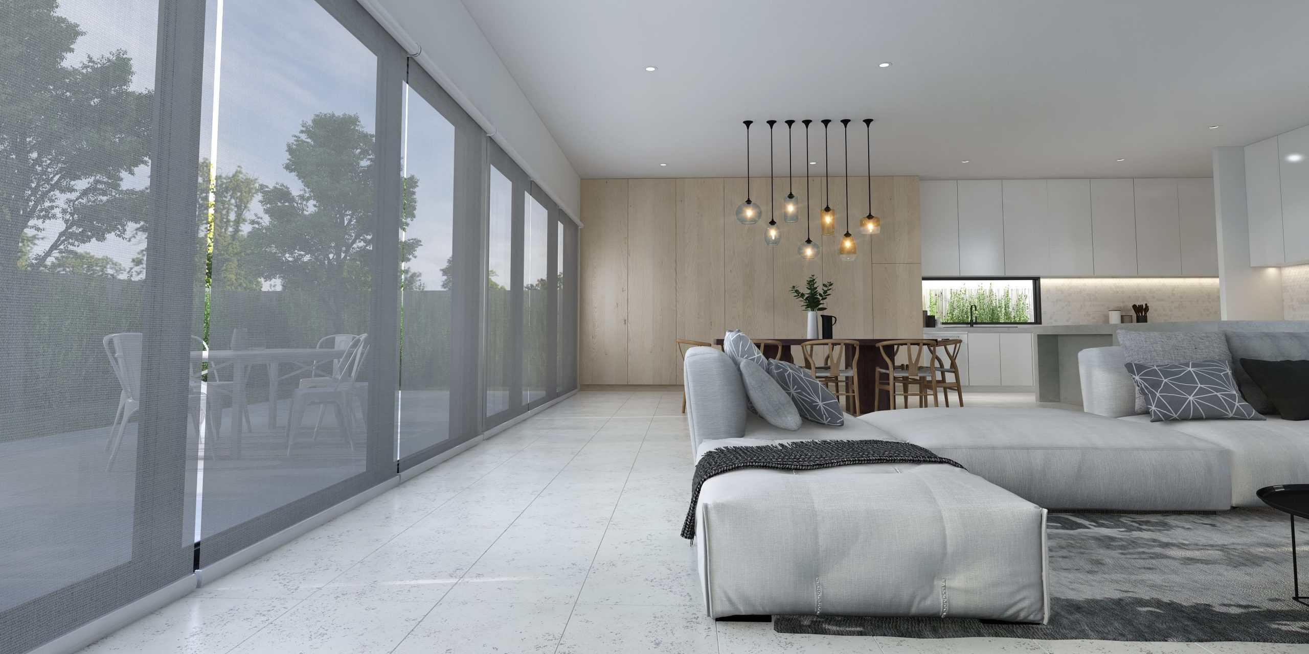 Modern open-plan living room with large windows, white sectional sofa, dining area, pendant lights, and a view of an outdoor patio and greenery.